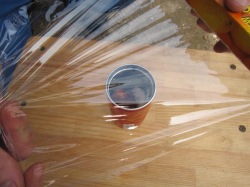 空き缶の口にラップを被せます。